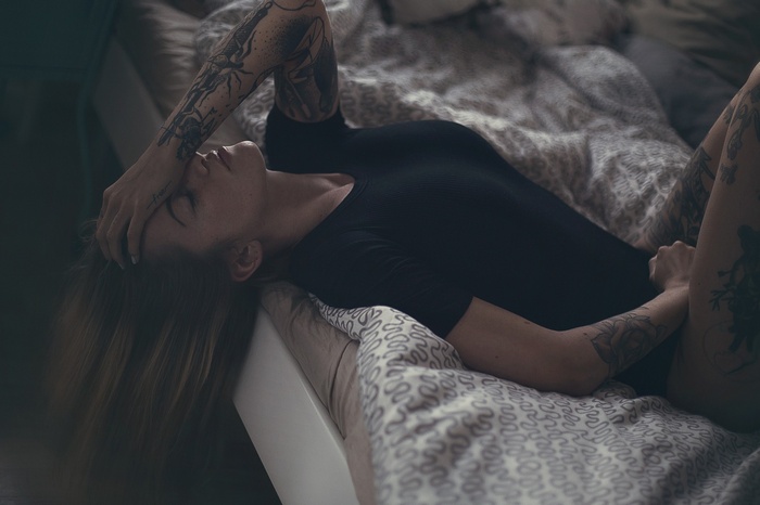Woman with tattoos lying in bed