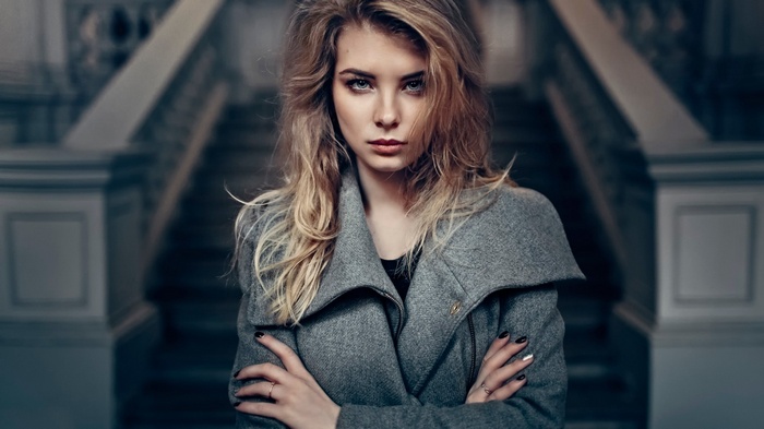 Irina Popova with blonde hair and grey coat