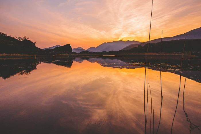 Lake landscape at sunset with mountain reflection