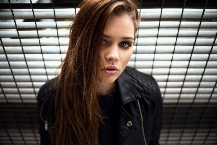 Woman with long brown hair wearing a leather jacket