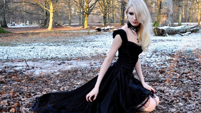 Woman in black dress in a snowy forest