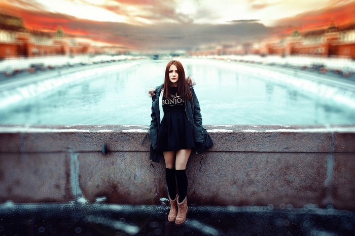 Woman in black dress and jacket on a bridge