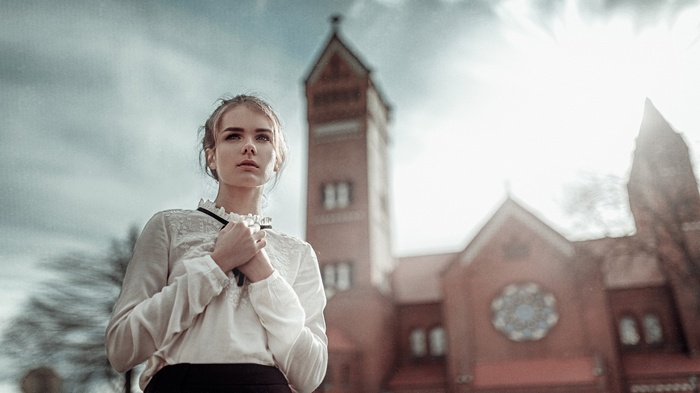 Woman in white blouse in front of a church