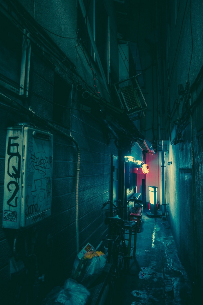 Night alley in Japan with graffiti and trash