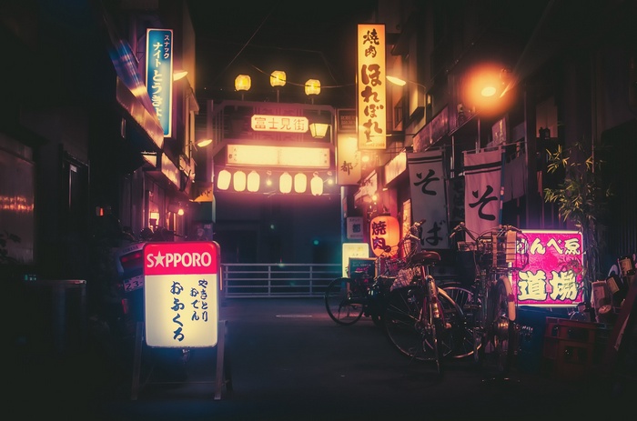 Neon signs and bicycles in a Japanese alley at night