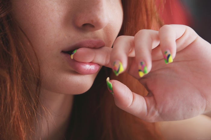 Woman with red hair biting her finger
