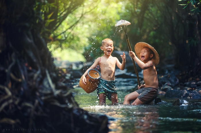 Two boys playing in a river in Thailand