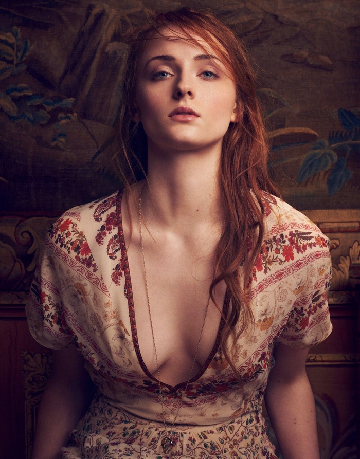 Sophie Turner with long red hair wearing a floral dress