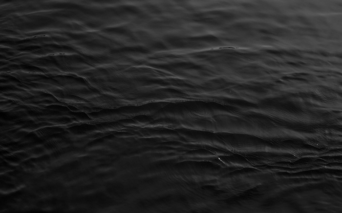 Monochrome image of dark, rippling water