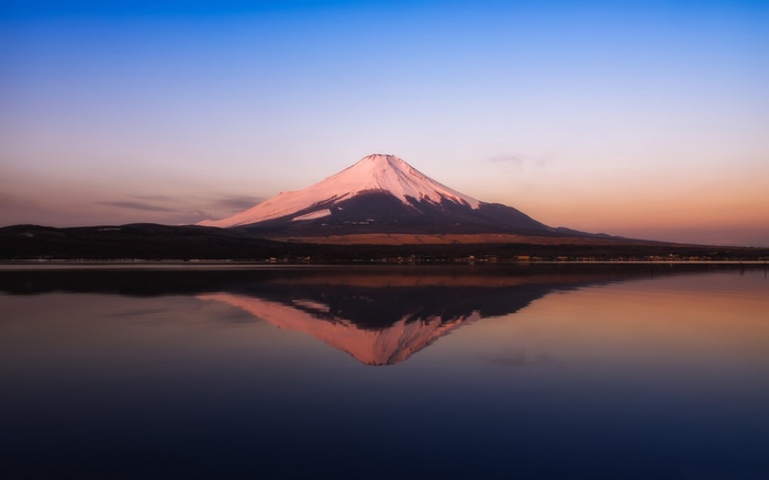 Mount Fuji reflected in a lake at sunset