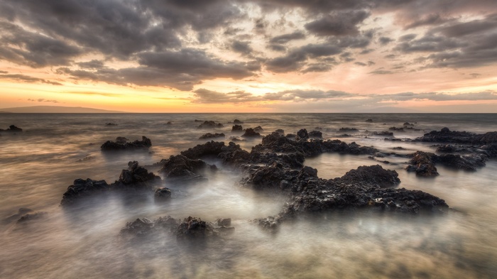 Rocky coastline at sunset with dramatic clouds
