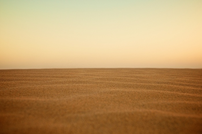 Minimalist sand dunes under a gradient sky