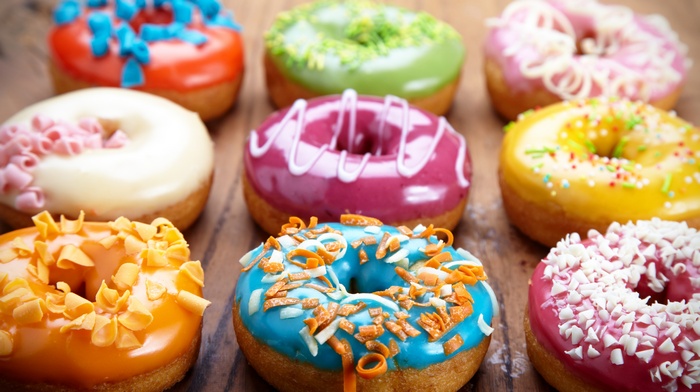 Assortment of colorful donuts on a wooden surface
