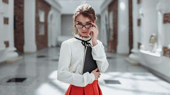 Woman with glasses holding a book