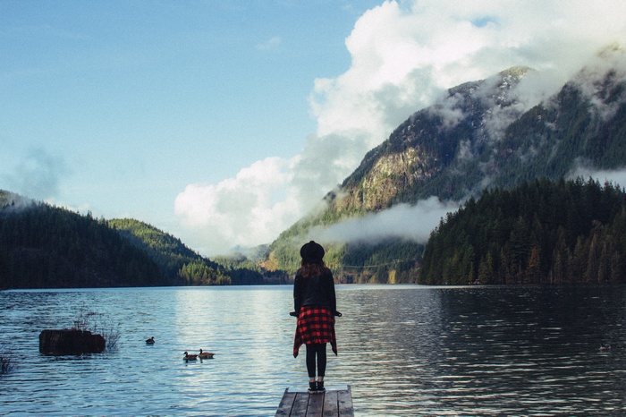 Woman on a dock overlooking a mountain lake