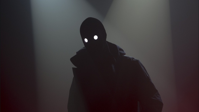 Dark figure with glowing eyes in spotlight