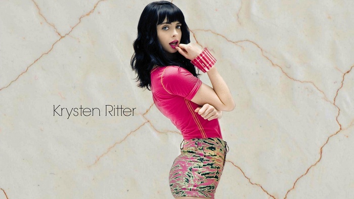 Krysten Ritter posing against a marble background