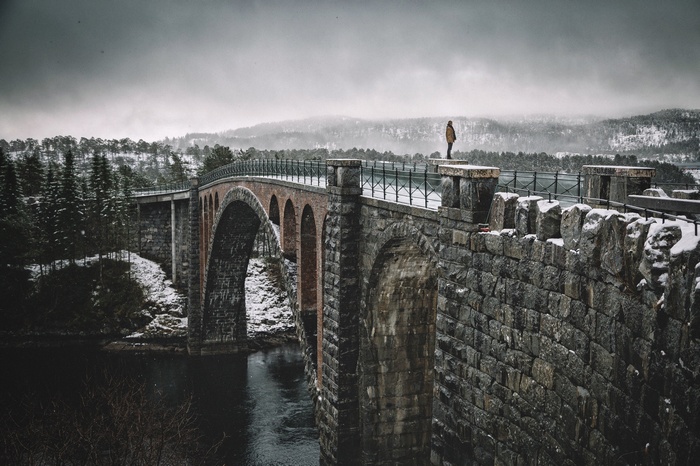 Man on a stone bridge in Norway during winter