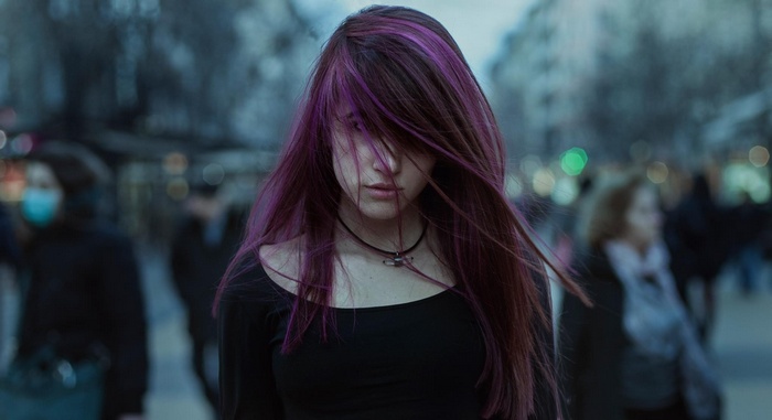 Woman with purple dyed hair in a crowd