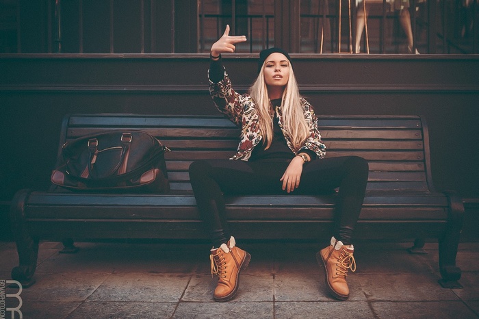 Woman in patterned jacket sitting on a bench