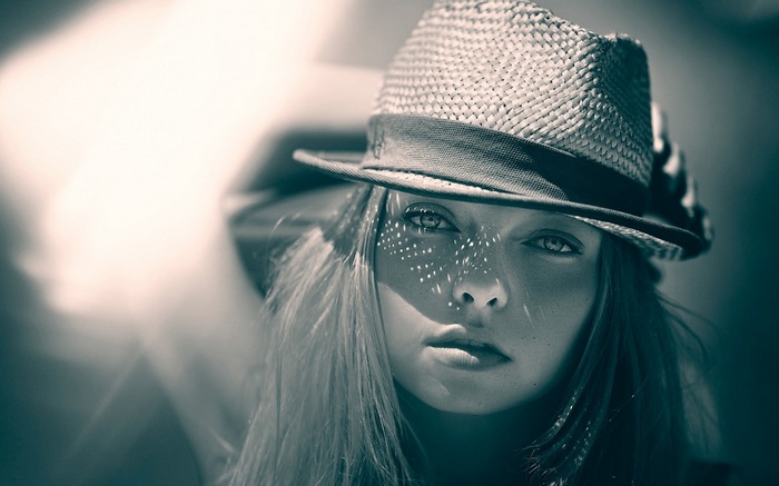 Woman wearing a straw hat with sunlight on her face
