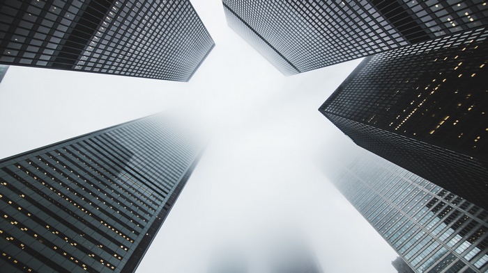Skyscrapers shrouded in mist, viewed from below
