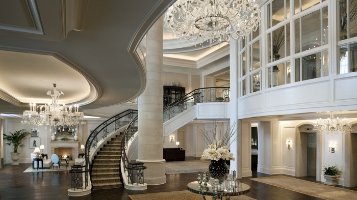 Luxury hotel lobby with grand staircase and chandeliers