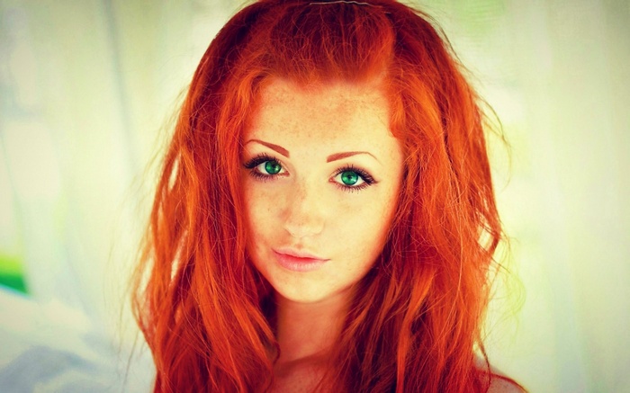 Portrait of a young woman with red hair and green eyes