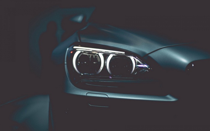 Close-up of BMW car headlights in the dark