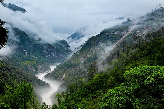 Misty Mountains River Valley with Trees and Clouds