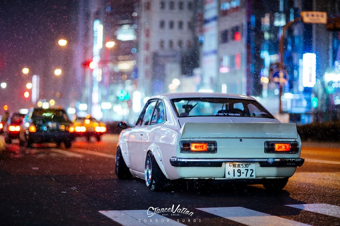 White Datsun Coupe in Rainy City at Night