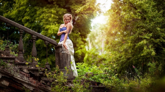 Blonde woman in a corset on a stone staircase