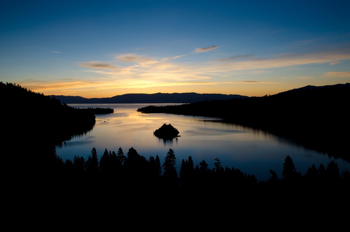 Sunset over a lake with an island and forest