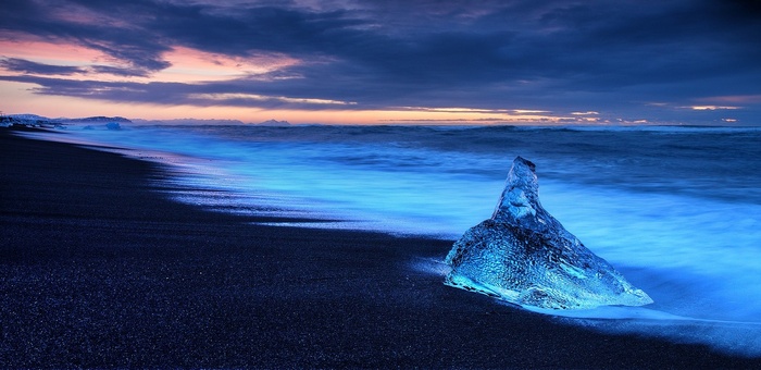 Black sand beach with ice and ocean at sunset, Iceland