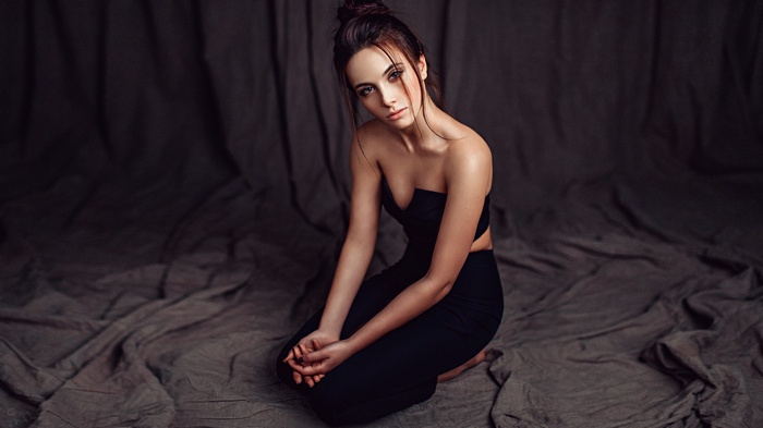 Kseniya Klimenko sitting on a draped fabric
