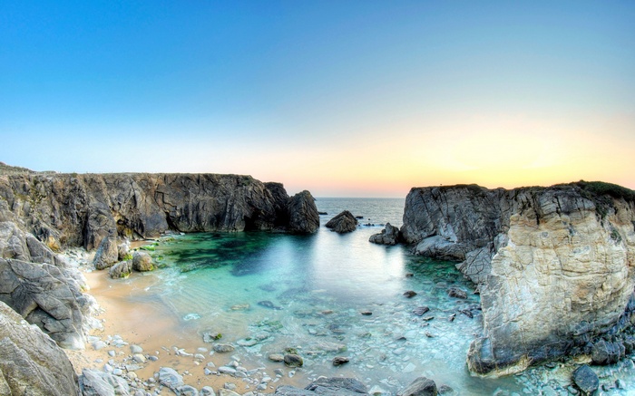 Rocky cove with clear turquoise water at sunset