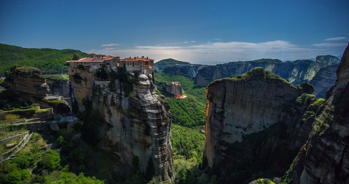 Meteora monasteries perched on rock formations under a starry sky