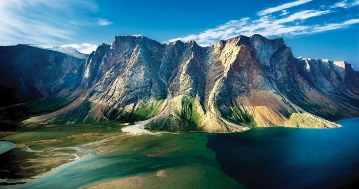 Majestic mountains meet a turquoise lake under a blue sky