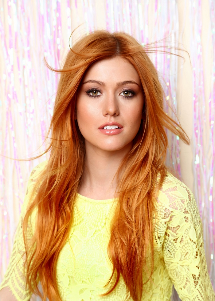 Katherine McNamara with long red hair in yellow clothing