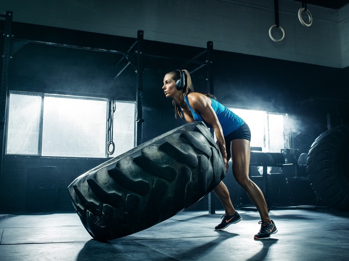 Janna Breslin flips a large tire in a gym