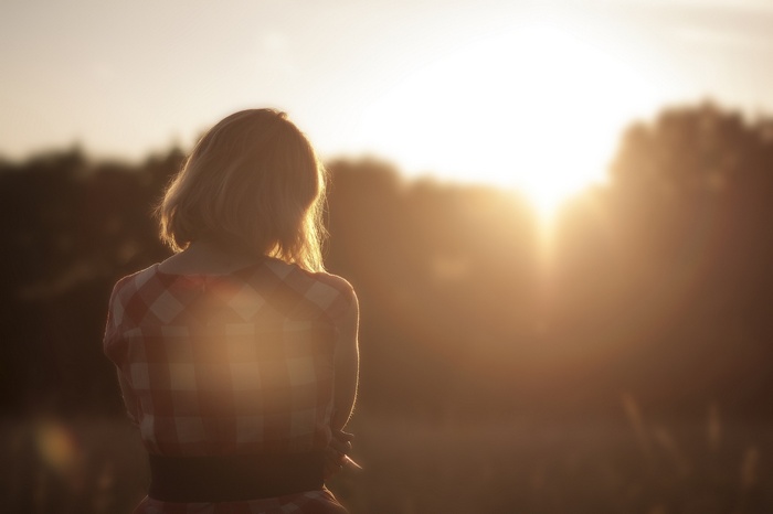 Woman in plaid shirt watching the sunset