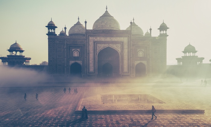 Taj Mahal in fog with people walking