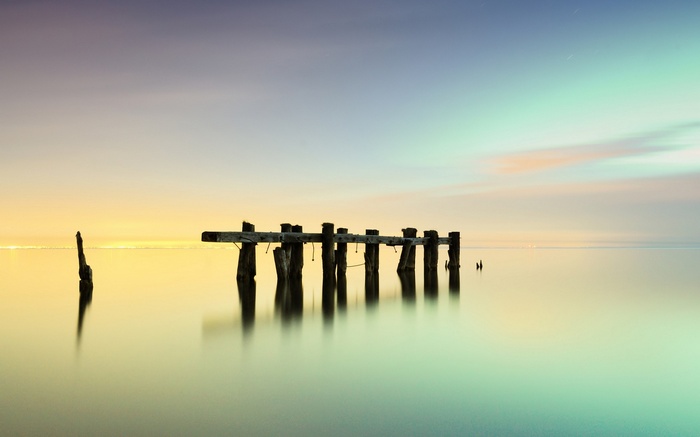 Old wooden pier on a calm sea at sunset