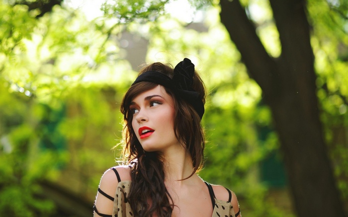 Woman with red lipstick and headband in sunlight