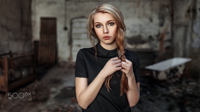 Portrait of a blonde woman with braids in abandoned building