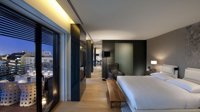 Luxury hotel bedroom with city view balcony at night