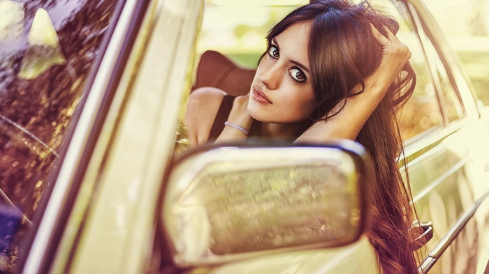 Woman leaning out of a vintage car window
