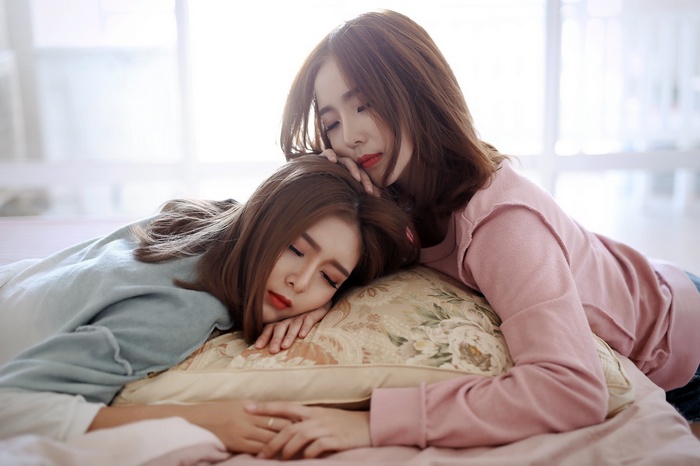Two Asian women sleeping on a pillow