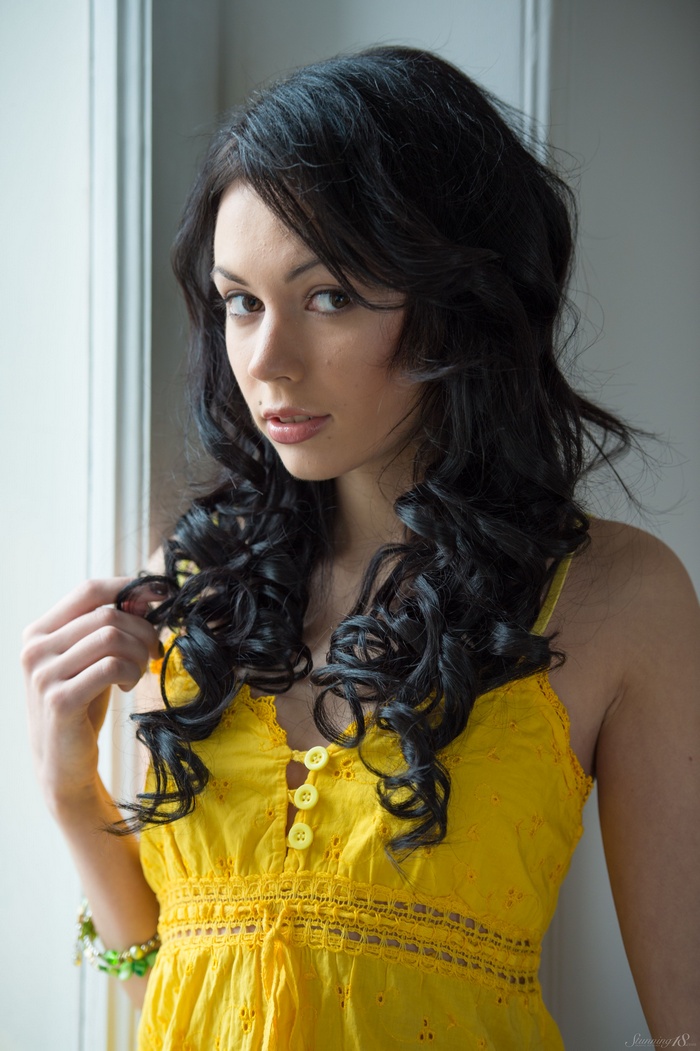 Shery Vi in a yellow dress by the window