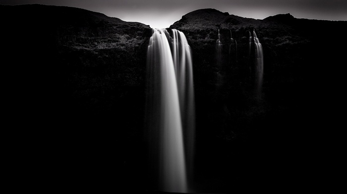 Monochrome long exposure of a waterfall cascading over rocks
